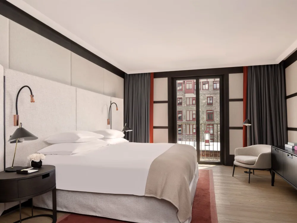 Serlas Wing Grand Room — newly renovated bedroom with king bed, curved wall lights and balcony view