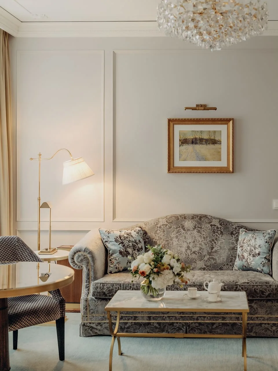 Deluxe Double Room, Village Side — lounge corner with damask sofa, chandelier and marble coffee table