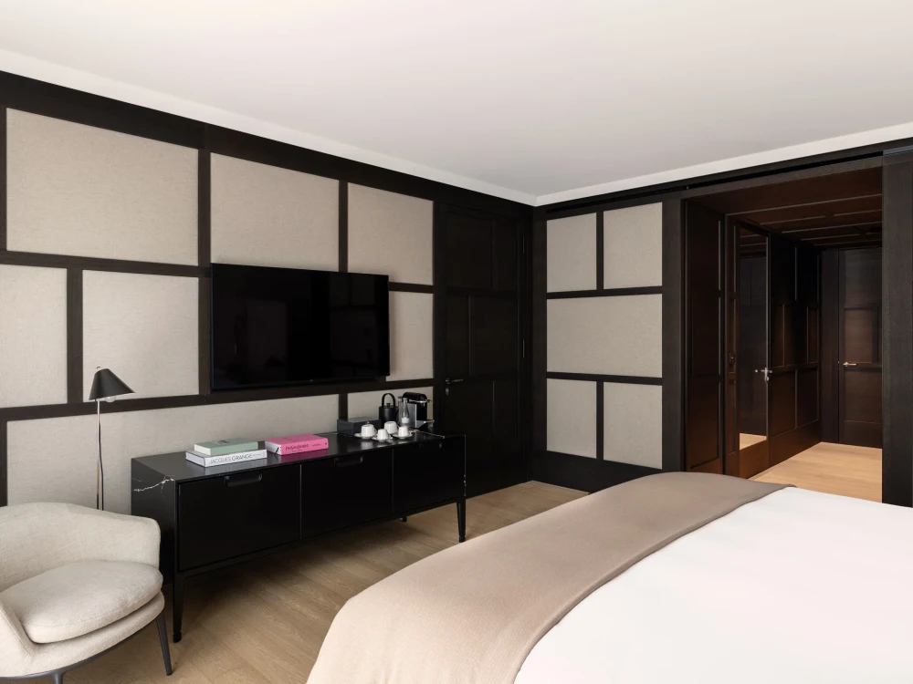 Serlas Room — newly renovated bedroom with dark wood panelling, king bed and lounge chair