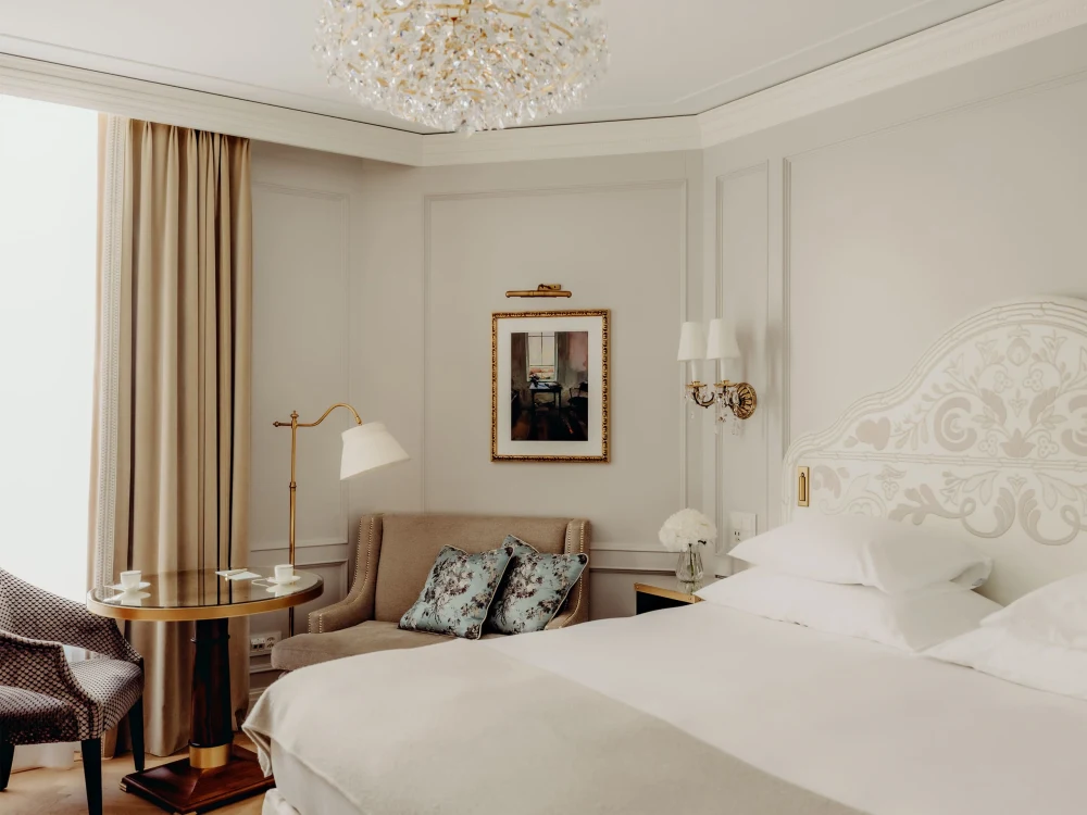 Superior Double Room, Village Side — bedroom with chandelier, king bed and seating corner